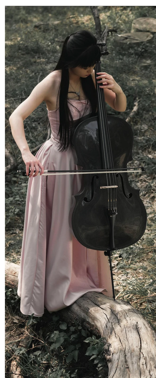 Cellist holding a carbon fiber cello outdoors