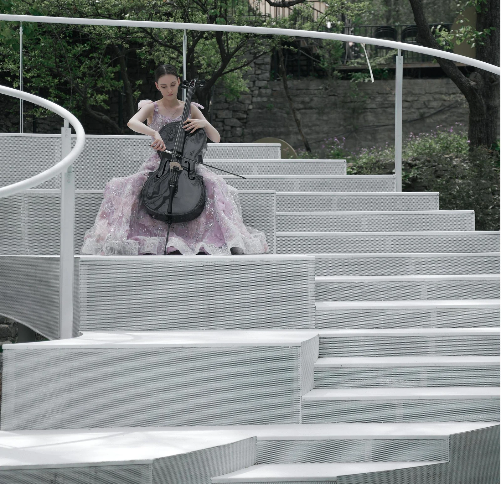 Cellist performing with a carbon fiber cello on an outdoor stage